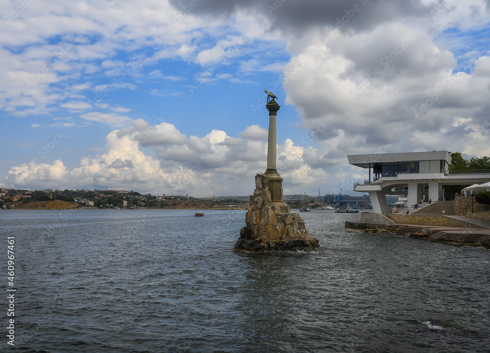 View from the embankment to the monument to the sunken ships in Sevastopol (Russia) in summer. Historic bay in the Black Sea. Blue sky with volumetric clouds View from the embankment to the monument to the sunken ships in Sevastopol (Russia) in summer. Historic bay in the Black Sea. Blue sky with volumetric clouds
