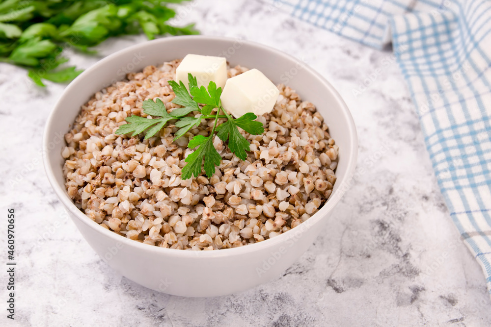 Freshly cooked buckwheat porridge in a plate on a gray background. Freshly cooked buckwheat porridge in a plate on a gray background.