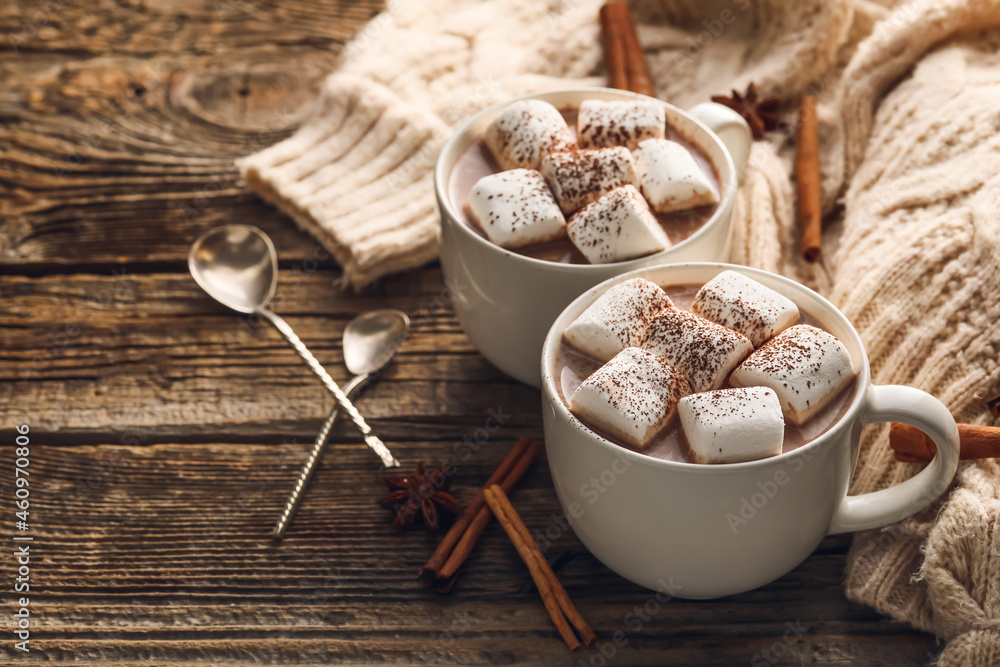 Composition with cups of hot cocoa drink, marshmallows and cinnamon on wooden background Composition with cups of hot cocoa drink, marshmallows and cinnamon on wooden background