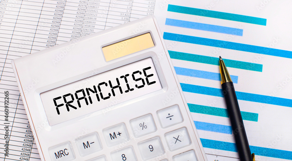 Against the background of reports and blue graphs, a pen and a white calculator with a test on the FRANCHISE screen. Business concept Against the background of reports and blue graphs, a pen and a white calculator with a test on the FRANCHISE screen. Business concept