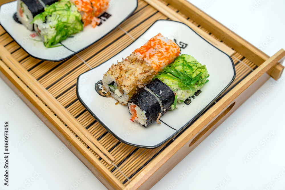 Several sushi on a white plate standing on a white background
Several sushi on a white plate standing on a white background