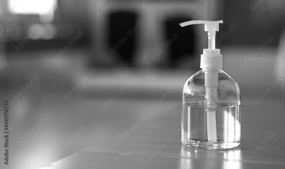Bottle of hand sanitizer on banner header background for COVID-19 Coronavirus concept. Black and white photo. Bottle of hand sanitizer on banner header background for COVID-19 Coronavirus concept. Black and white photo.