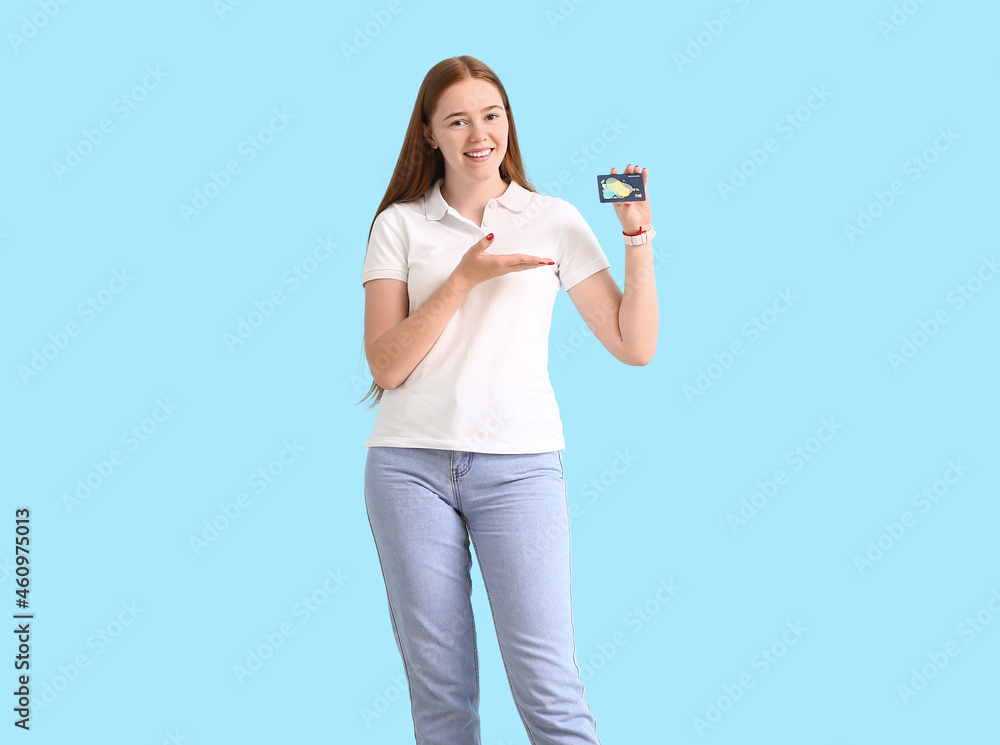 Young woman with credit card on color background