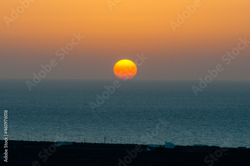 Fototapeta Naklejka Na Ścianę i Meble -  The sun sets behind the horizon line on the sea