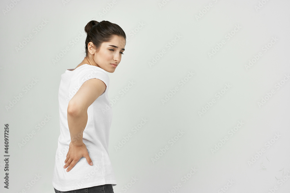 woman in white t-shirt health problems back pain woman in white t-shirt health problems back pain