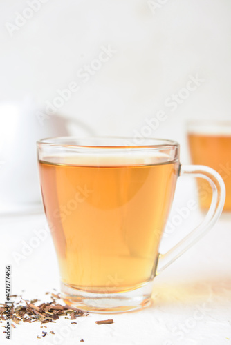 Glass cup of tasty hojicha green tea on white background