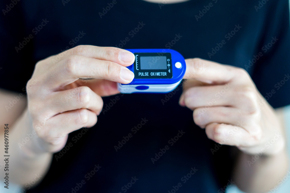 Hands female using pulse oximeter device on finger, healthcare monitoring concept Hands female using pulse oximeter device on finger, healthcare monitoring concept