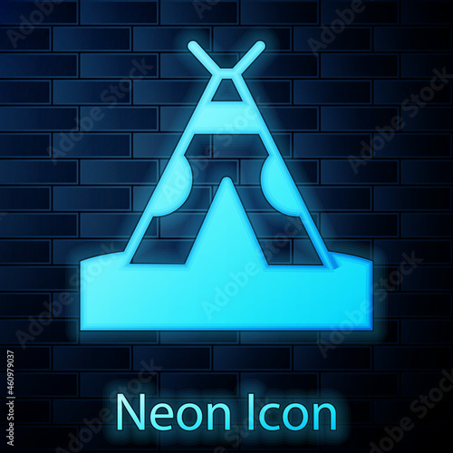 Glowing neon Traditional indian teepee or wigwam icon isolated on brick wall background. Indian tent. Vector