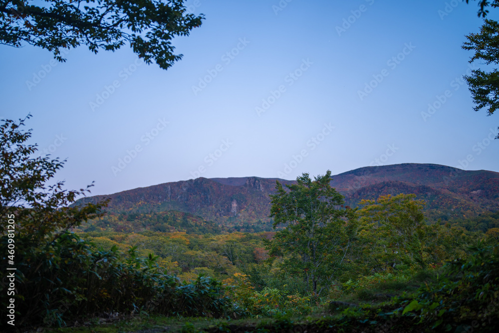 Fototapeta premium 城県栗原市、秋田県湯沢市、雄勝郡東成瀬村、岩手県一関市にある栗駒山近くの湖畔キャンプ場の紅葉の時期の風景 Scenery of the lakeside campground near Mt. Kurikoma in Kurihara City, Castle Prefecture; Yuzawa City, Akita Prefecture; Higashinaruse Village, Oga