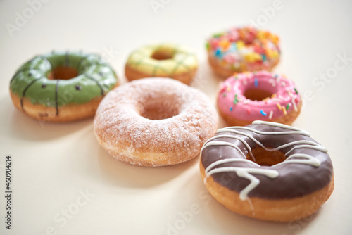 Close-up of various glazed donuts placed in shape of triangle on table