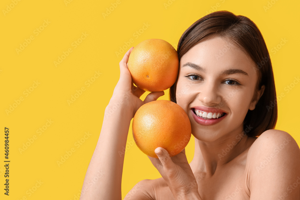 Naked young woman with grapefruits on color background. Vegan Day Naked young woman with grapefruits on color background. Vegan Day