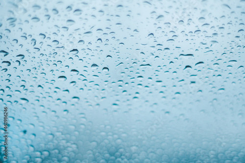 Raindrops on the window. Water droplets on glass. Blue tone