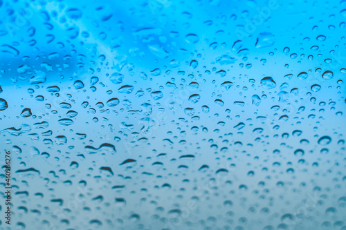 Raindrops on the window. Water droplets on glass. Blue tone