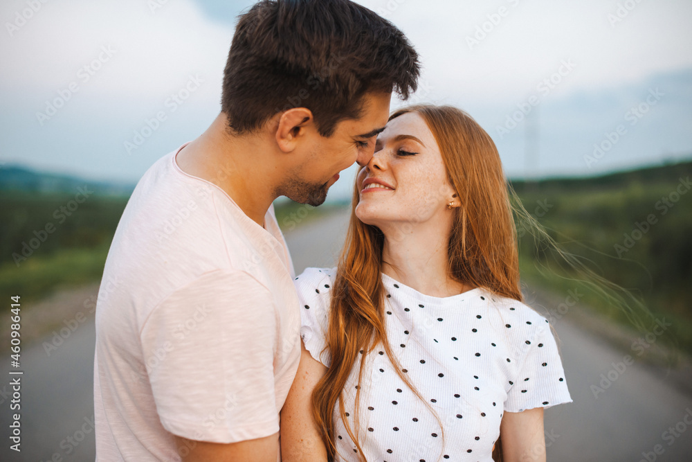 Fashion portrait of a couple kissing in the sunlight. Spring season. Pretty lover embracing on a road. Fashion portrait of a couple kissing in the sunlight. Spring season. Pretty lover embracing on a road.
