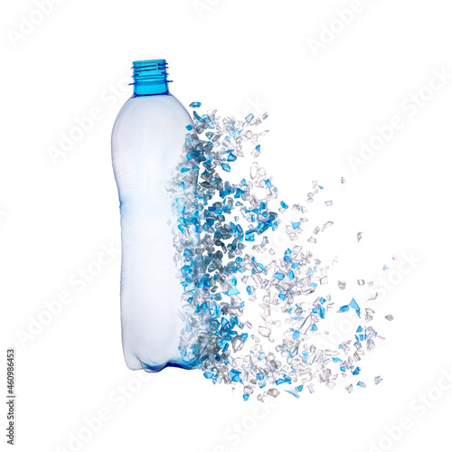 Top view of blue plastic bottle with PET bottle  transparent flakes around in white background. Plastic pollution recycle and World Environment Day concept.