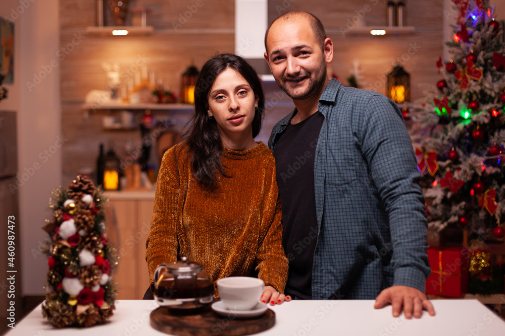 Portrait of happy family looking into camera while celebrating christmas winter holiday standing in xmas decorated kitchen. Cheerful joyful enjoying spending wintertime together. Christmastime Portrait of happy family looking into camera while celebrating christmas winter holiday standing in xmas decorated kitchen. Cheerful joyful enjoying spending wintertime together. Christmastime