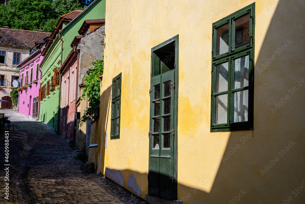 Old colorful painted houses in the historical center of the Sighisoara citadel, in Transylvania (Transilvania) region of Romania, in a sunny summer day.