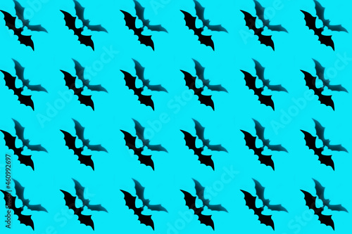 Halloween holiday concept. Pattern from paper bats on a blue background.