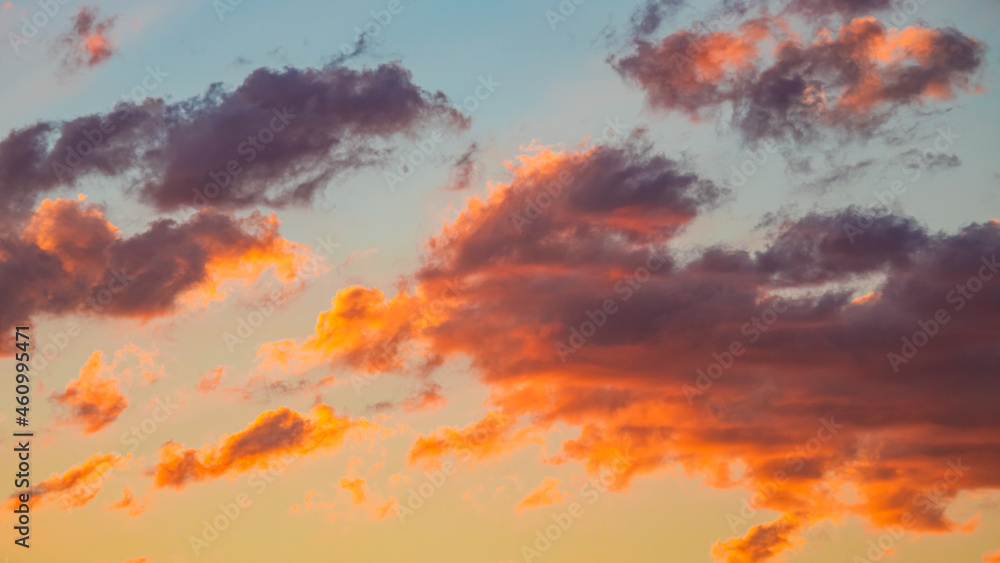 Dramatic orange clouds at sunset. Cloudscape abstract background photo.