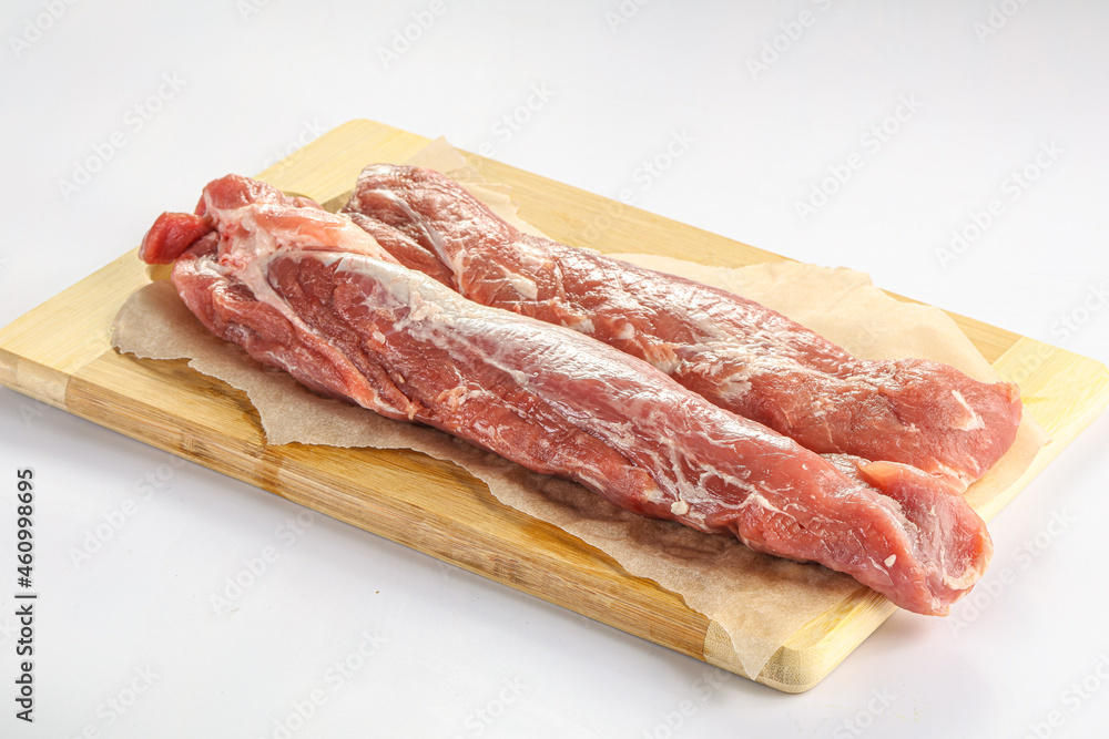Raw pork tenderloin over board