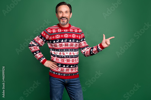 Photo of mature happy positive man point finger empty space sale index isolated on green color background