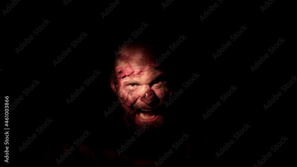 Zombie male with makeup for halloween concept creep on floor in dark indoor