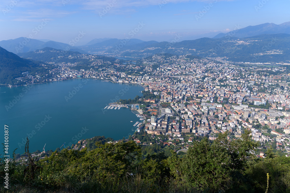 Aerial view form Mountain Monte Brè bay of Lake Lugano and City of Lugano on a sunny late summer morning. Photo taken September 11th, 2021, Lugano, Switzerland.