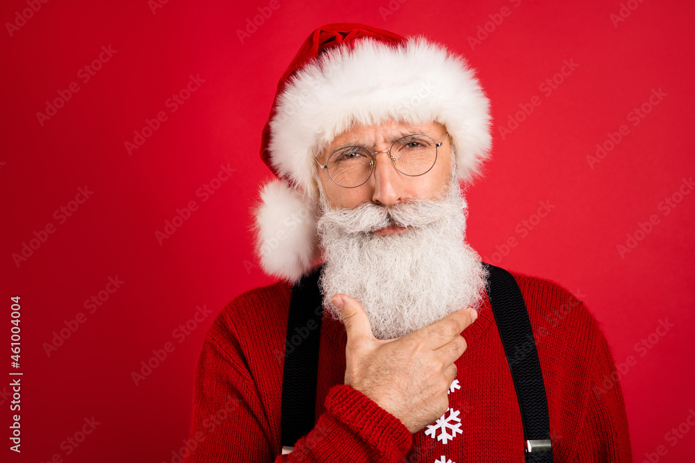 Naklejka premium Portrait of attractive gloomy suspicious Santa overthinking wintertime isolated over bright red color background