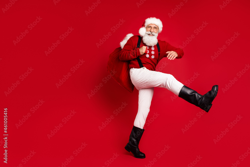 Full length body size view of cheerful Santa carrying giftboxes midnight night isolated over bright red color background Full length body size view of cheerful Santa carrying giftboxes midnight night isolated over bright red color background