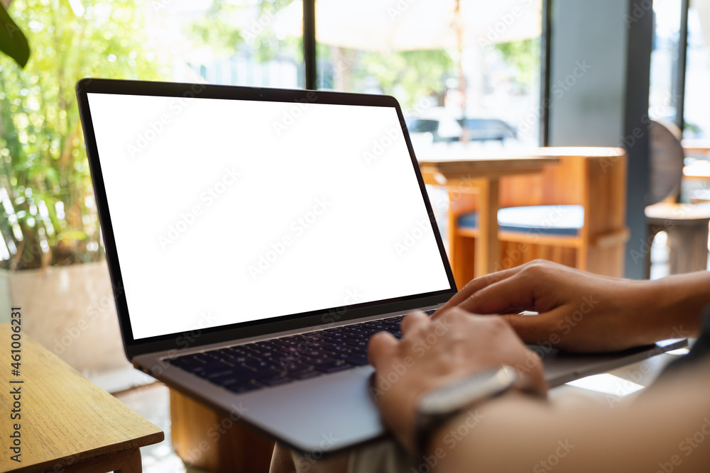 Mockup image of a woman using and typing on laptop with blank white desktop screen