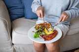 A woman eating American breakfast at home