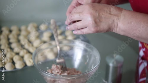 a woman makes homemade dumplings in the kitchen