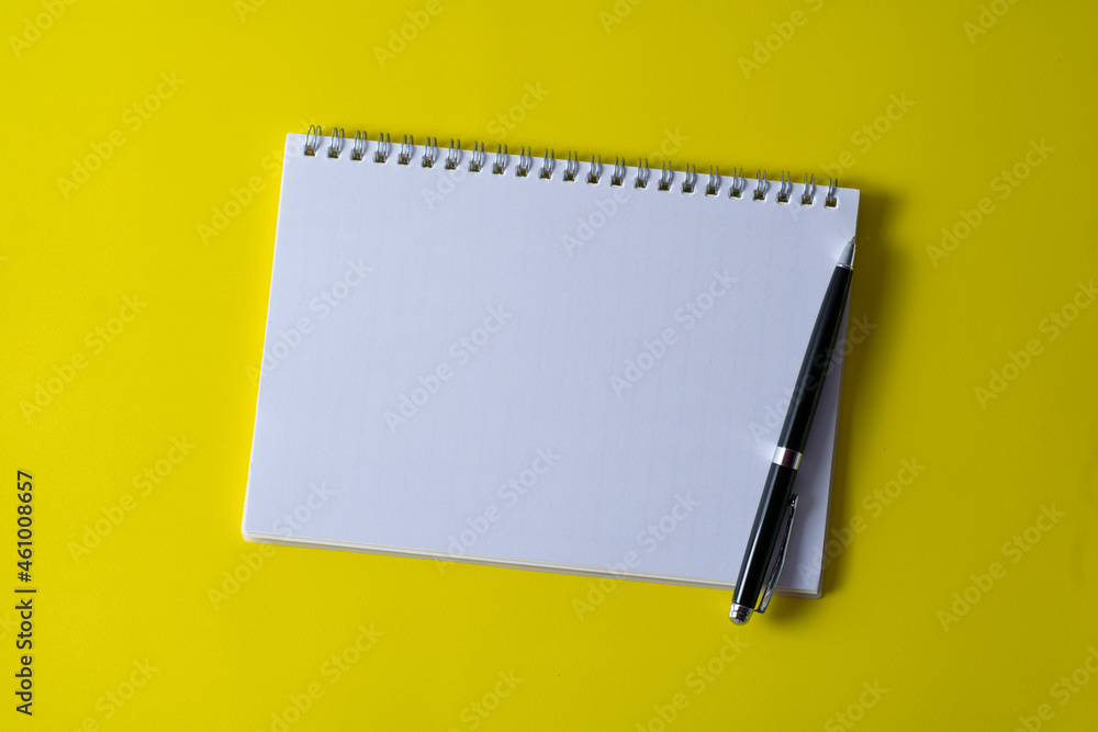 Top view of blank open notebook on yellow background and different objects. Minimal flat lay style. Top view of blank open notebook on yellow background and different objects. Minimal flat lay style.