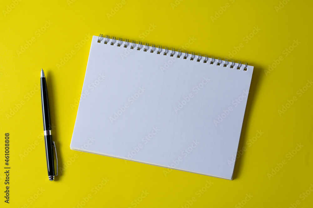 Top view of blank open notebook on yellow background and different objects. Minimal flat lay style. Top view of blank open notebook on yellow background and different objects. Minimal flat lay style.
