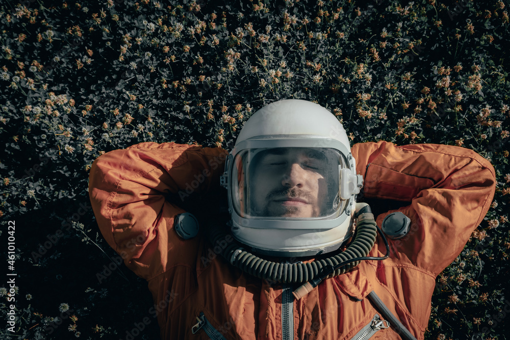 Fotka „Closeup of cosmonaut wearing space suit and space helmet taking a  nap while lying on grass outdoors. Portrait of astronaut sleeping on  meadow“ ze služby Stock | Adobe Stock