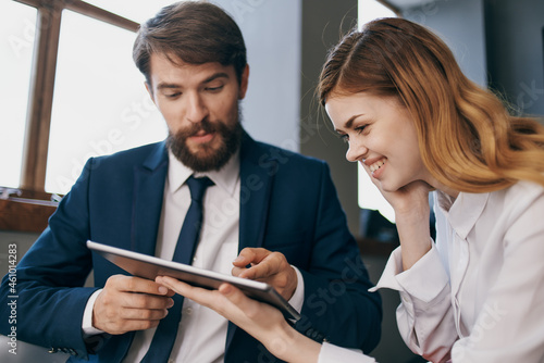 man and woman in business suits work with a tablet officials teamwork