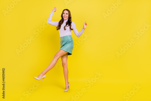 Full size portrait of carefree cheerful lady chilling look empty space have good mood isolated on yellow color background