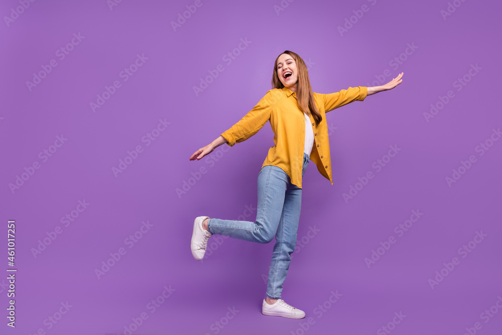 Full body profile side photo of excited woman have fun dance party carefree isolated over violet color background Full body profile side photo of excited woman have fun dance party carefree isolated over violet color background