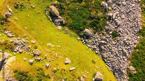 Top down view rocky terrain with grass and hiking trail with no people outdoors in KAzbegi national park. photo