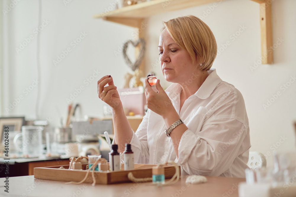 Close-up of a pipette with oil and a glass bottle. woman pouring perfume in bottle. Perfume creating workshop Close-up of a pipette with oil and a glass bottle. woman pouring perfume in bottle. Perfume creating workshop