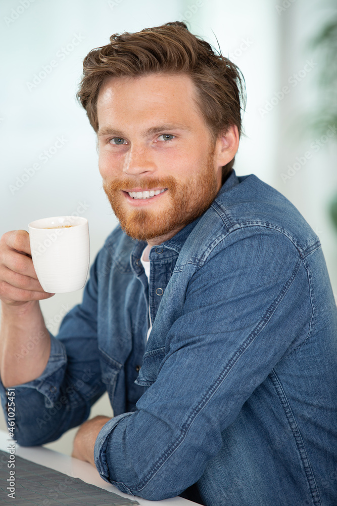 young man drinking tea on the sofa young man drinking tea on the sofa