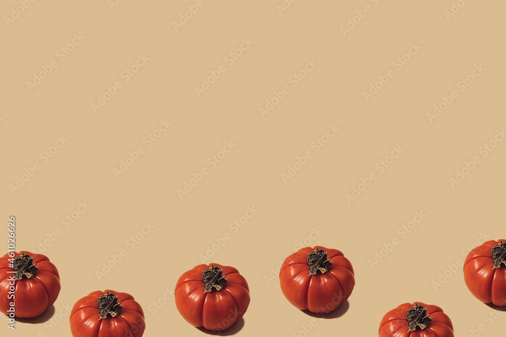 Autumn sunlit yellow background with pumpkins or tomatoes. Flat lay harvest or halloween concept. Creative layout of colorful vegetables. Copy space. Autumn sunlit yellow background with pumpkins or tomatoes. Flat lay harvest or halloween concept. Creative layout of colorful vegetables. Copy space.