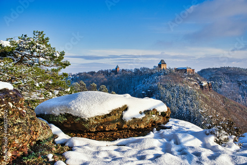 Castle Nideggen, Germany in winter mountain landscape and snow covered rock in foreground