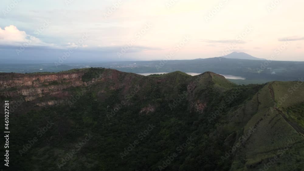 Cinemaic Aerial view over inactive volcano crater covered with vegetation, a lake and another volcano on the background. Volcano in Central America. Masaya, the “Mouth of Hell”, Nicaragua. Close up Cinemaic Aerial view over inactive volcano crater covered with vegetation, a lake and another volcano on the background. Volcano in Central America. Masaya, the “Mouth of Hell”, Nicaragua. Close up