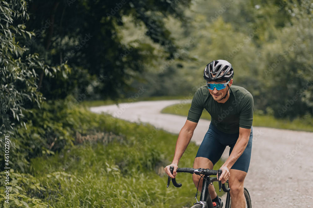 Happy man riding black bike among green forest Happy man riding black bike among green forest