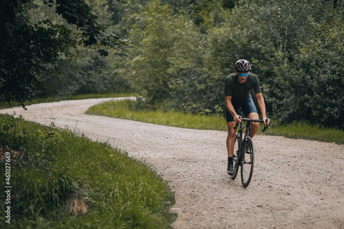Strong male athlete riding bike on forest trail © Tymoshchuk