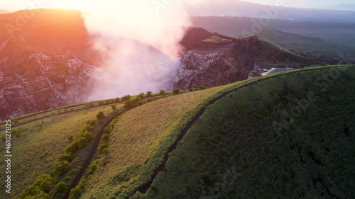 Aerial shot over a crater full of  steam from Erupting Volcano in Central America durung sunset. Masaya, the “Mouth of Hell”, Nicaragua. Close up photo