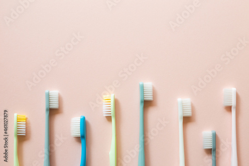 Colorful toothbrushes on pink background. top view  copy space