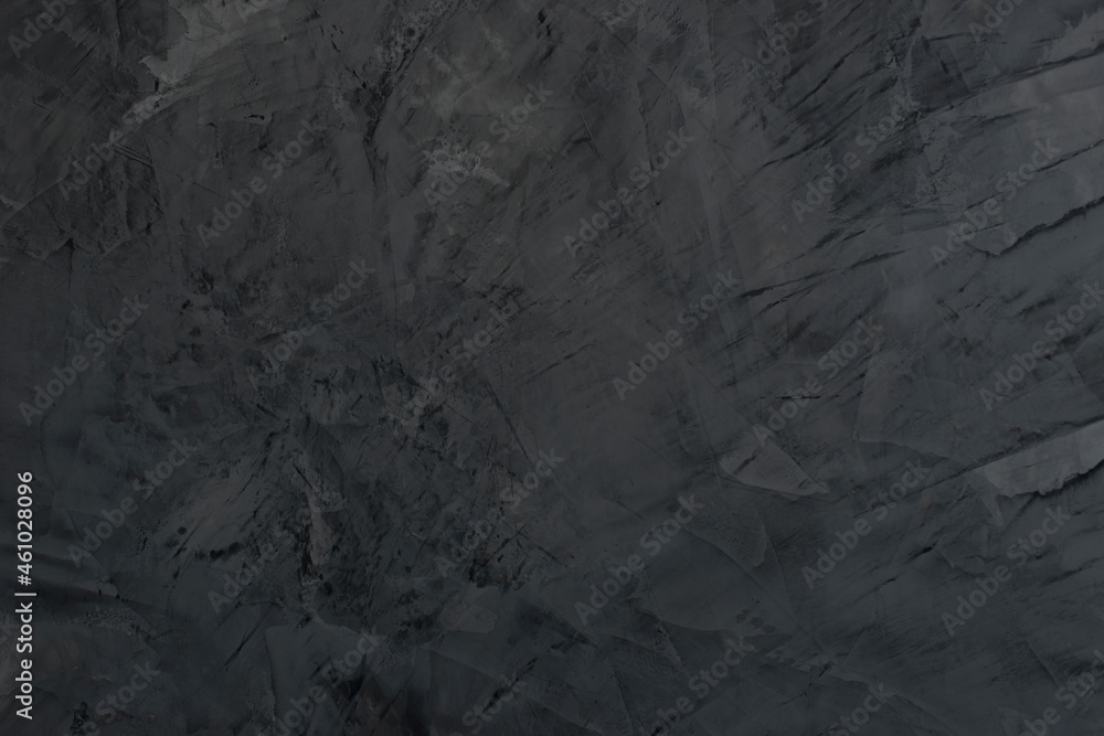 Black textured wall. The background texture of Venetian plaster is black color. Decorative plaster on the wall in the dark gray interior Black textured wall. The background texture of Venetian plaster is black color. Decorative plaster on the wall in the dark gray interior