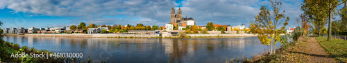 Panoramic view over Magdeburg historical downtown, Elbe river, city park and the ancient medieval cathedral in golden Autumn colors at blue cloudy sky and sunny day, Magdeburg, Germany.